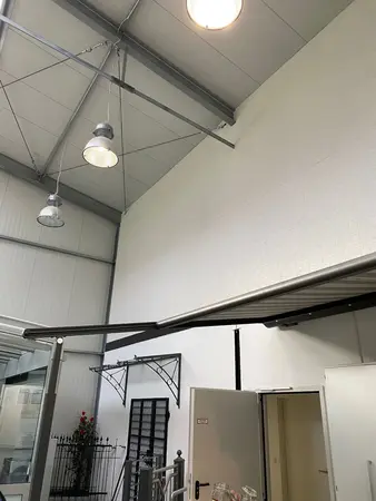 Moderne Industriehalle mit hohen Decken, LED-Beleuchtung und Metallkonstruktionen.