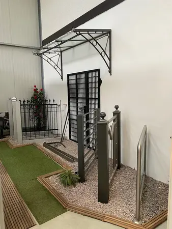 Verschiedene Zaun- und Geländermodelle aus Metall, dekorativ im Ausstellungsraum präsentiert.